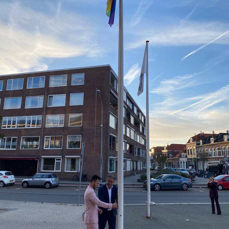 regenboogvlag wordt gehesen tijdens coming out day
